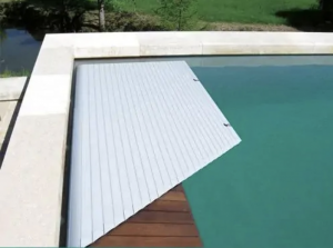 Swimming pool roller shutter with submerged grating